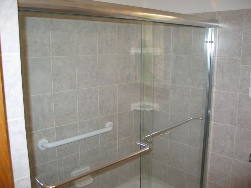 Finished product:  Shower area
Here's a view of the shower.  We put in some sleek new shower doors.  You can also see the large grab-bar at the rear, as well as the corner shelves in place.
