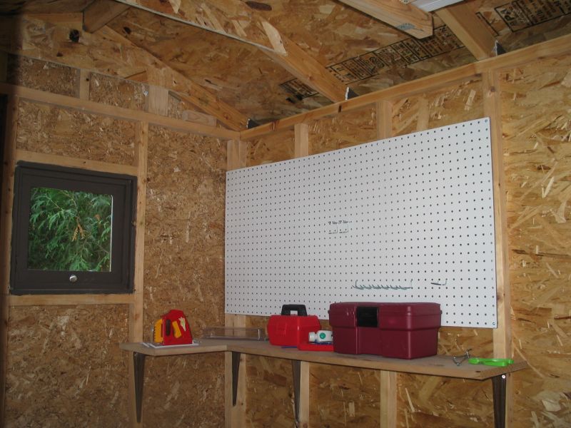 It's finished!
Here's an inside view of the 'workshop' area.  We hung up pegboard and put in a small workbench.  You can also see the finished window, which opens out.
