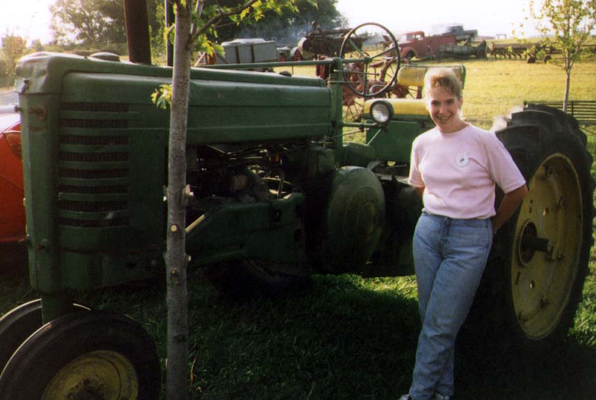 Unrestored
Most of the tractors at the show were restored, but here Cathy stands by a Deere in with its original paint.
